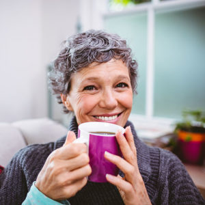 elderly woman drinking a cup of coffee