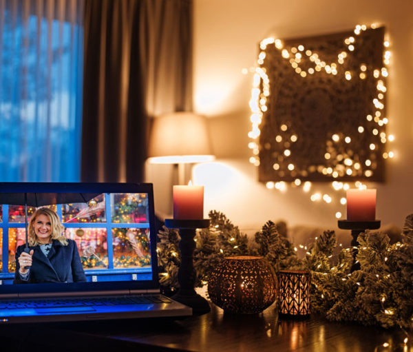 Woman on tv screen in room decorated for Christmas